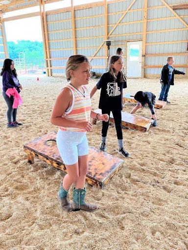 girls playing cornhole CORNHOLE